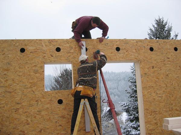 Haus in Fertigteilen
Die Wände werden mit der Wasserwaage vertikal ausgerichtet und mit einer provisorischen Stütze verankert. Die Öffnungen zum Einblasen des Dämmmaterials sind bereits vorgefertigt.