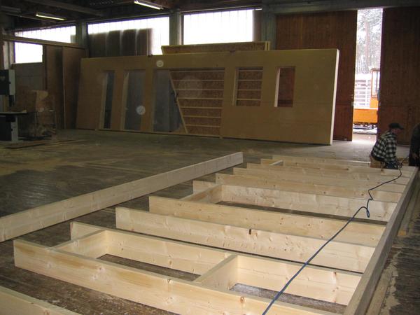 Wandaufbau in der Zimmerei
Die werksseitige Produktion ist angelaufen, Holzskelettelemente am Boden handgerecht aufgereiht und erstes Wandelement ist bereits fertig für den Abtransport.